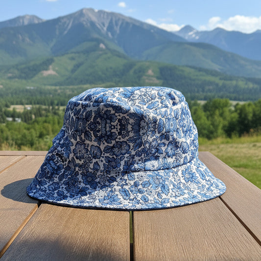 A blue and white patterned bucket hat resting on a wooden deck outdoors.