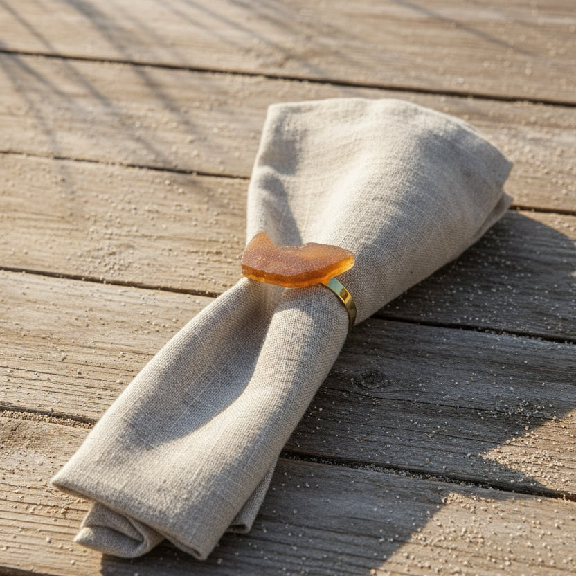 Brown sea glass napkin ring on linen napkin on beachside table