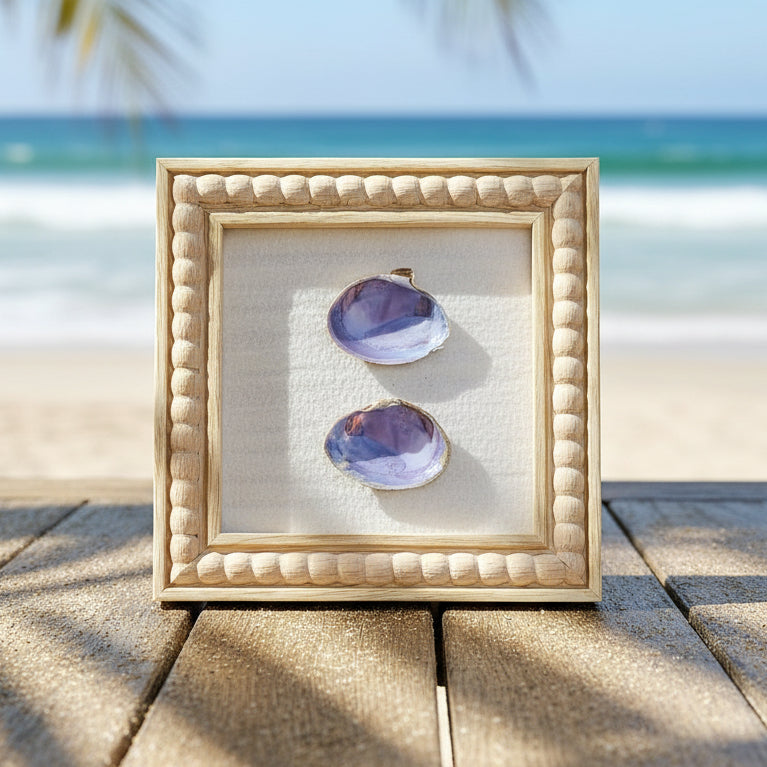 Shell art in square frame on beachside table