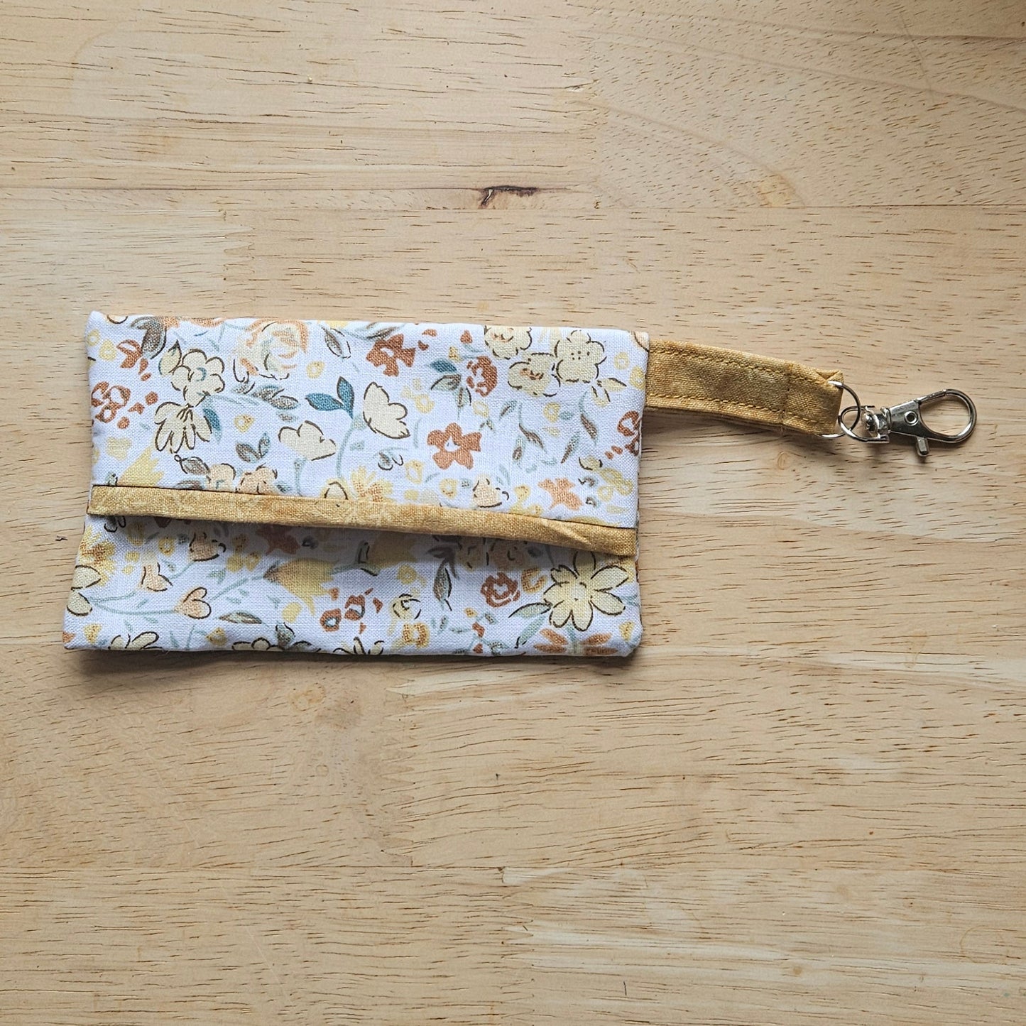 Floral patterned keychain and pouch on a wooden surface